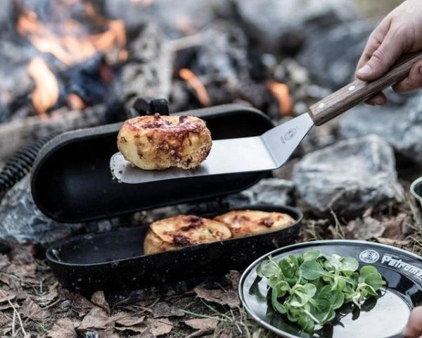 Tava din fonta si spatula Petromax cu bucata de cartof pe ea