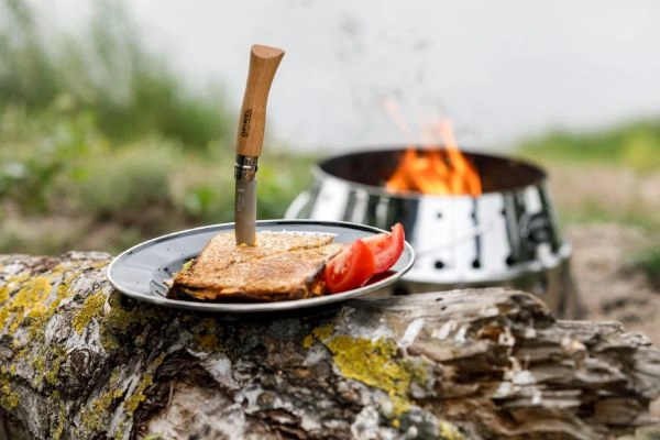 Sandwich pe farfurie neagra emailata si gratar Petromax pe fundal